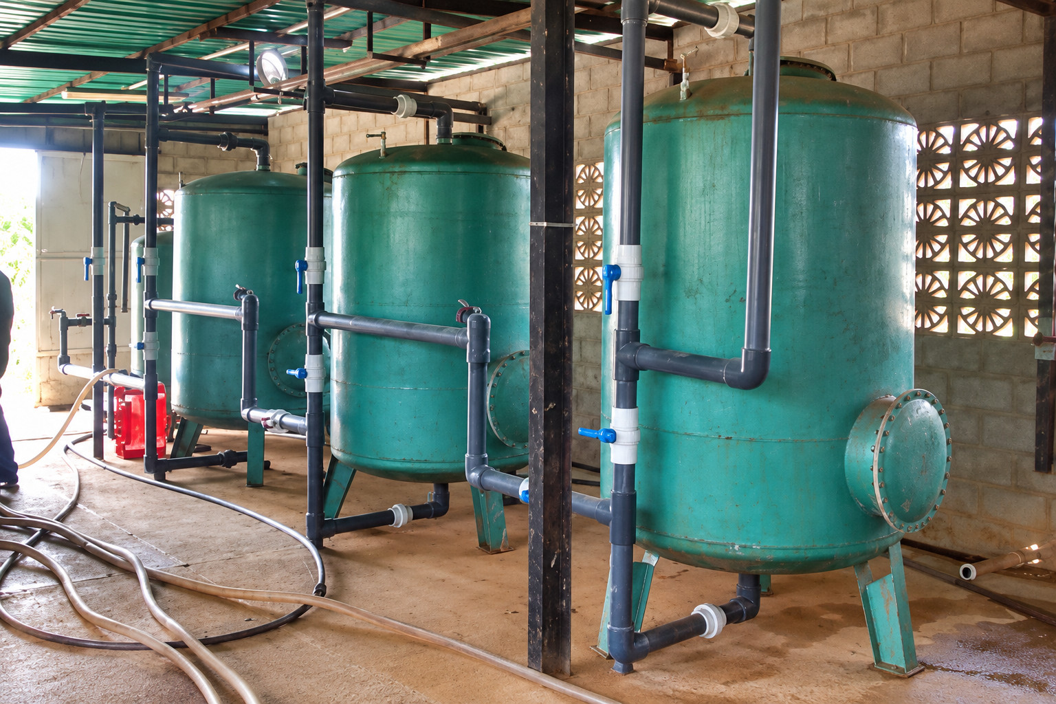 Sistema de filtración con tanques y tuberías para tratamiento del agua. Imagen regenerada de referencia.