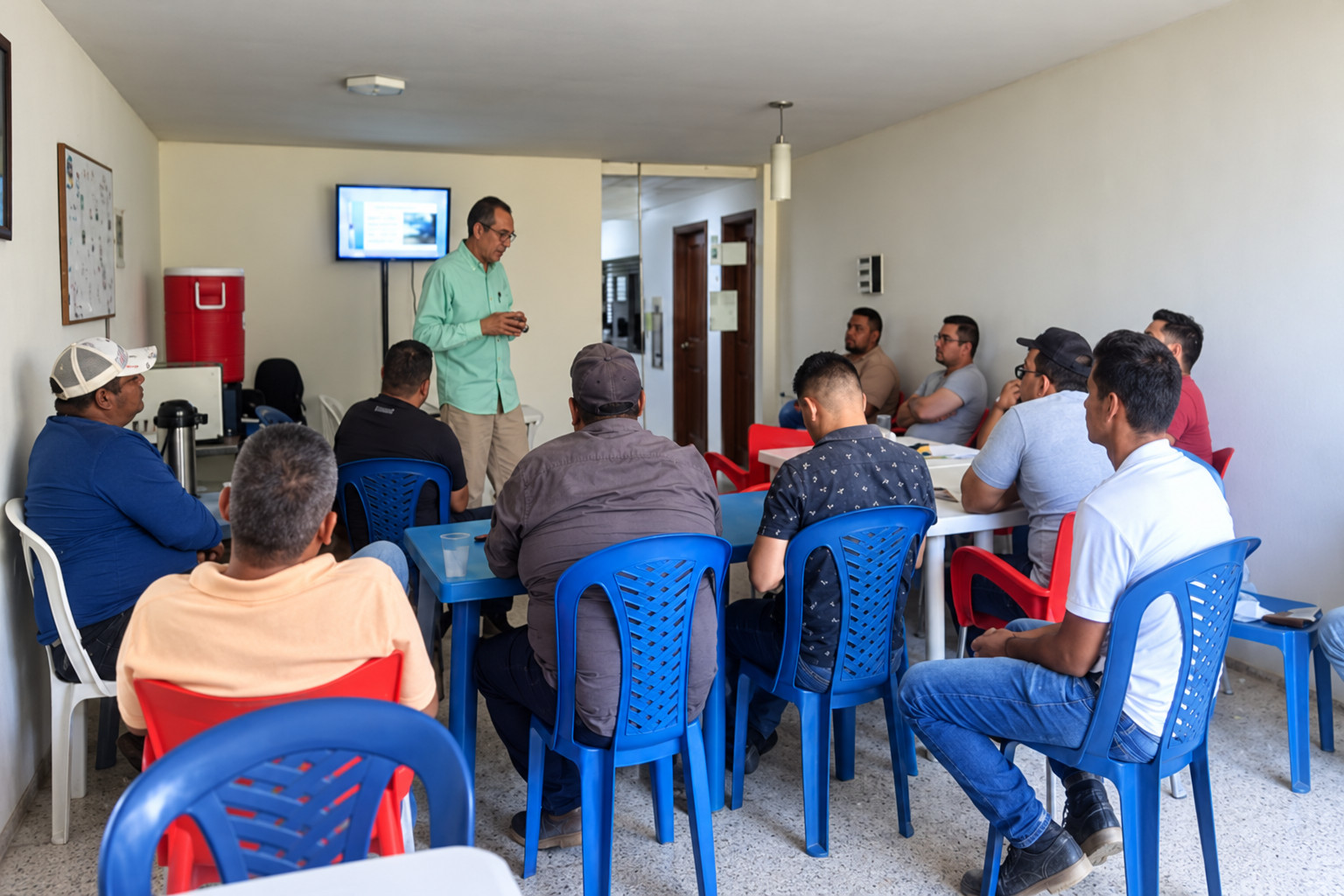 Instructor y participantes en una sesión de adiestramiento técnico. Imagen regenerada de referencia.